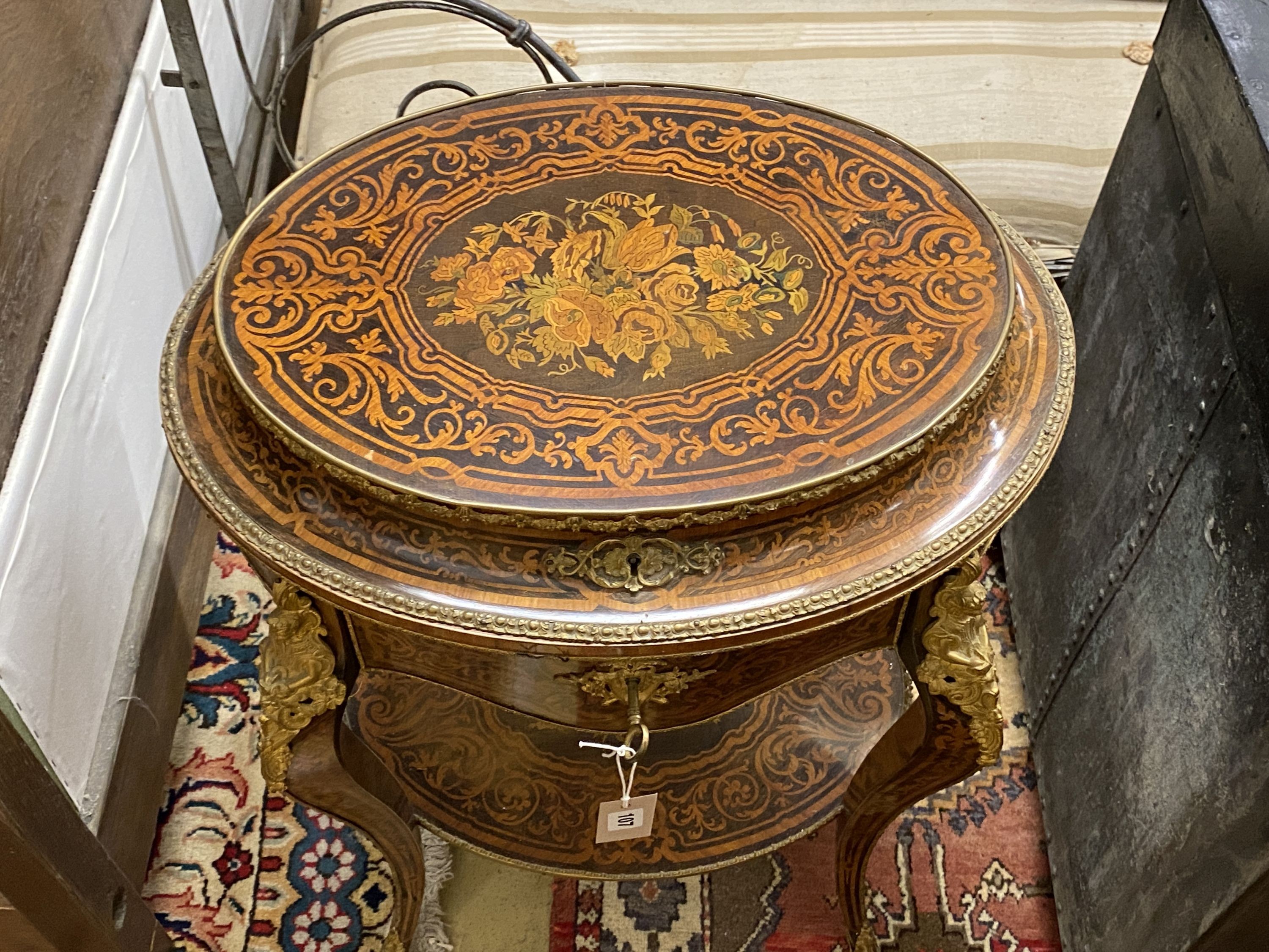 A Louis XVI style marquetry inlaid oval gilt metal mounted two tier work table, width 56cm, depth 42cm, height 78cm